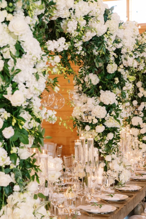 White floral arch framing an elegantly set head table